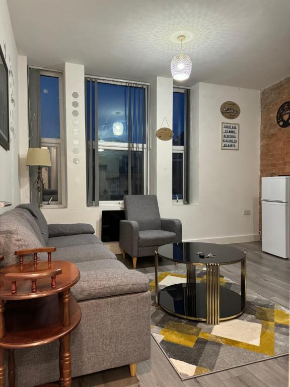 a living room with a couch and a table at Icon Residencia Apartment in Manchester