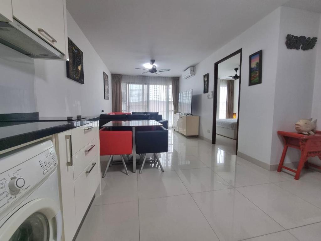 a kitchen with a washing machine and a dining room at Néo Condo Jomtien Pattaya in Jomtien Beach