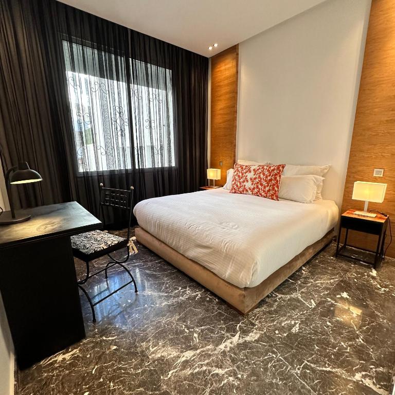 a bedroom with a bed and a large window at Supérieur Suite Balima B25 in Rabat