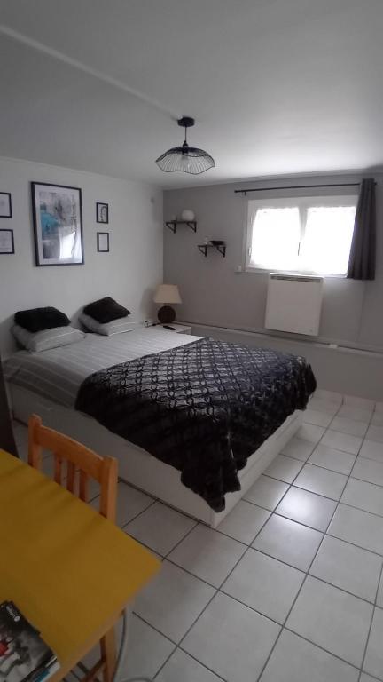 une chambre avec un lit, une table et une fenêtre dans l'établissement coin tranquille, à Pont-du-Château