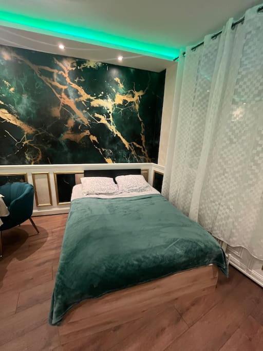 une chambre avec un lit avec un tableau sur le mur dans l'établissement Appartement Gare-Centre-Rouen, à Rouen