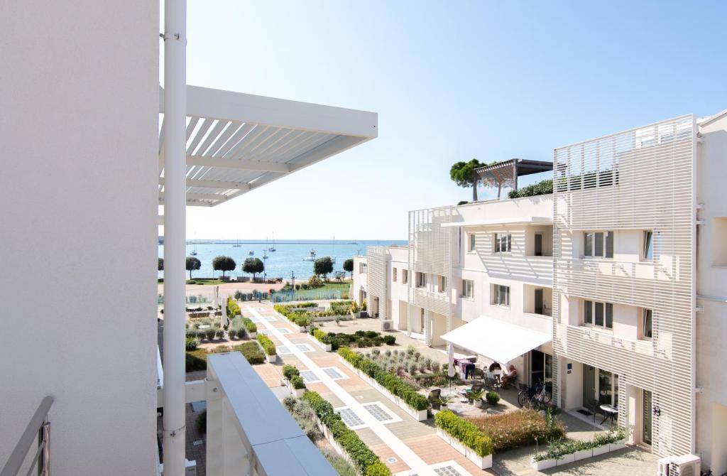 uitzicht op het strand vanaf het balkon van een gebouw bij Garden Palace - Vitamin Sea Appartment with Teracce in Umag
