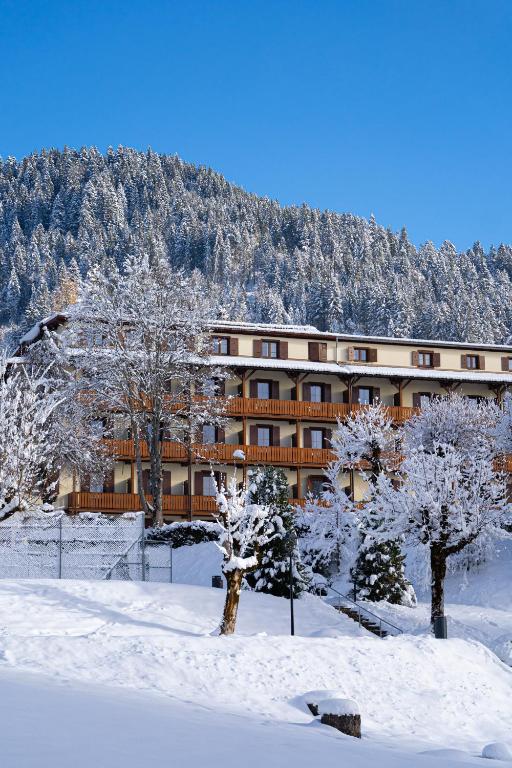 a building with snow covered trees in front of it at Villars Lodge in Villars-sur-Ollon