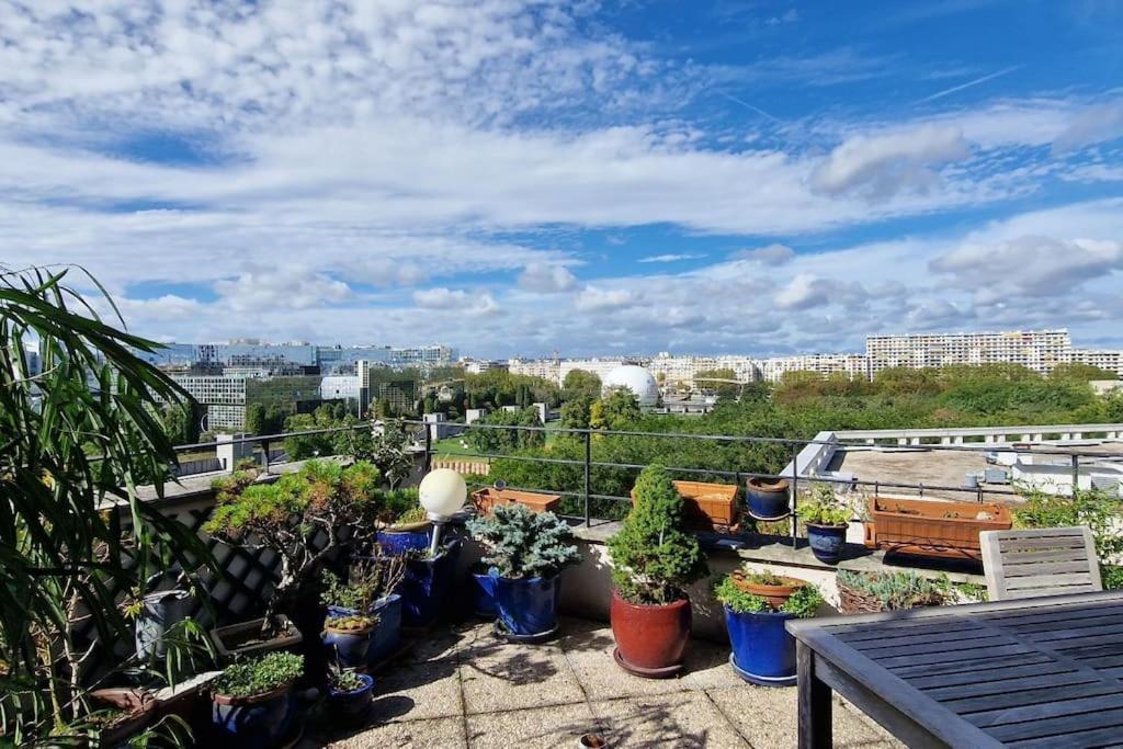 d'un balcon avec des plantes en pot sur le toit. dans l'établissement Duplex double terrasses 4P, à Paris