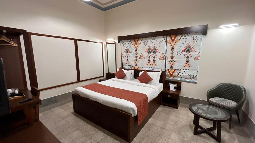 a hotel room with a bed and a chair at The Jais Boutique Stay in Varanasi