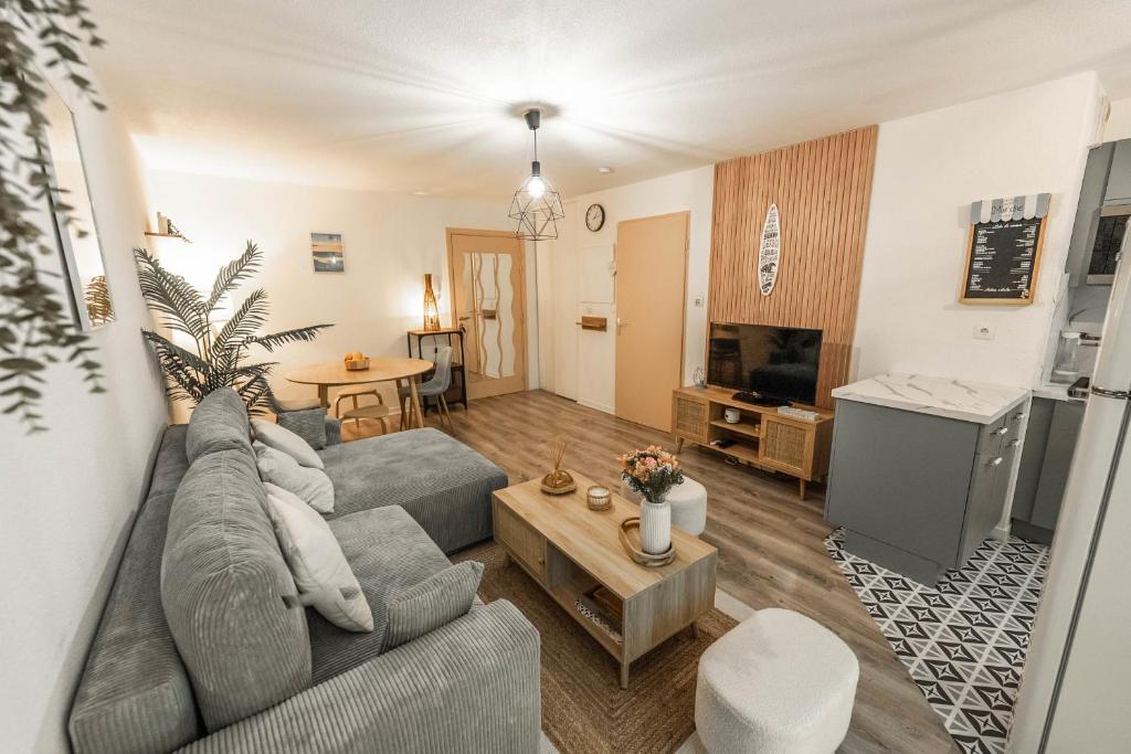 un salon avec un canapé et une table dans l'établissement Cosy apartment with terrace near Bordeaux, à Mérignac