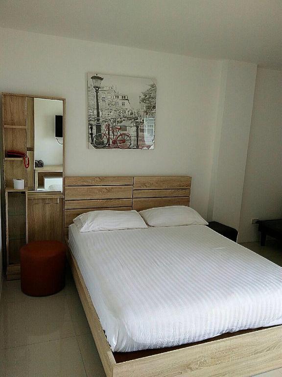a bedroom with a large white bed and a mirror at KC Kamala Guesthouse in Kamala Beach