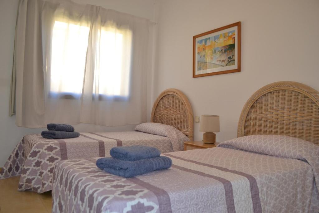 pokój z 3 łóżkami i niebieskimi ręcznikami w obiekcie Villa Meloneras - Exclusive Chill Out w mieście San Bartolomé