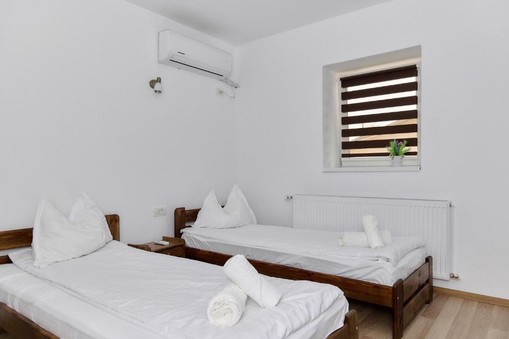 een kamer met twee bedden en een raam bij Casa Marko in Nădlac