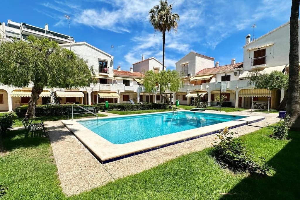 a swimming pool in a yard next to a building at Tu casita de la playa in Santa Pola