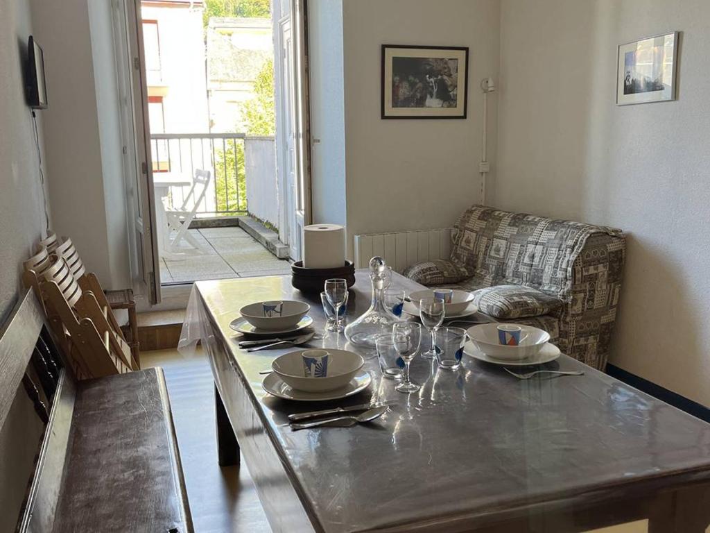 コトレにあるAppartement à Cauterets - 5/6 pers., Terrasse, 30 m², Parking Proche - FR-1-234-158のダイニングルームテーブル(皿、ワイングラス付)
