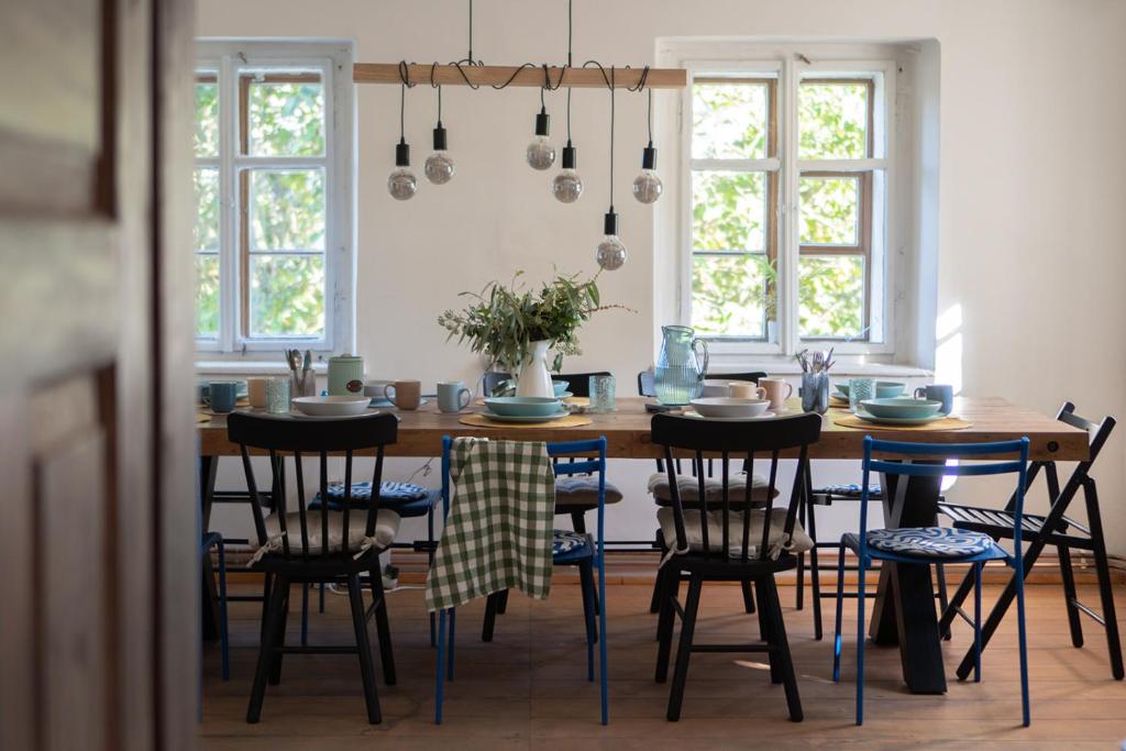 a dining room with a wooden table and chairs at Roubenka Bohéma in Verneřice