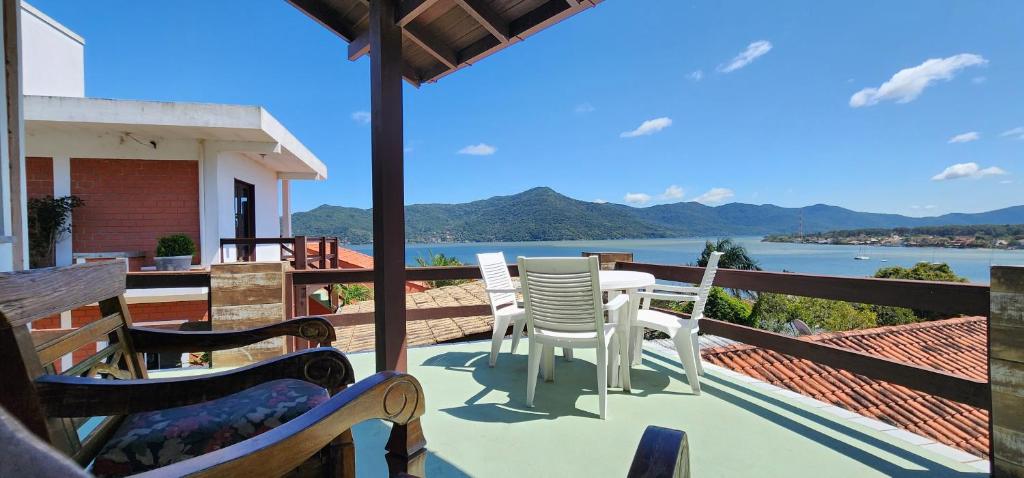 a balcony with chairs and a table with a view of the water at Residencial Marcelo e Irene in Florianópolis
