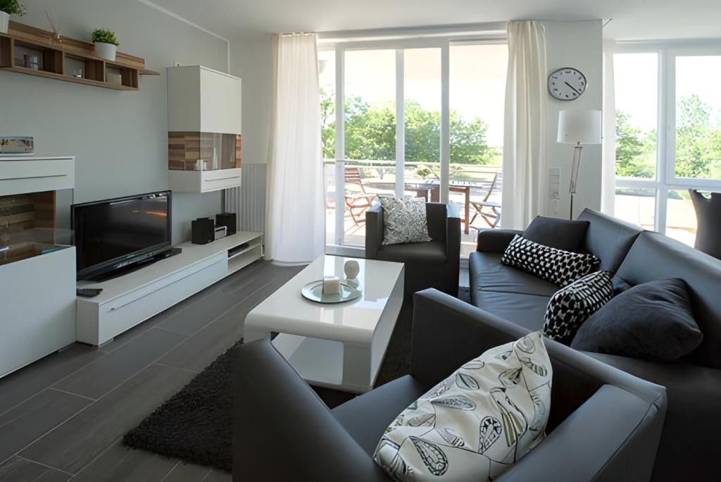 a living room with a couch and a tv at Leuchtturm 7 in Grossenbrode