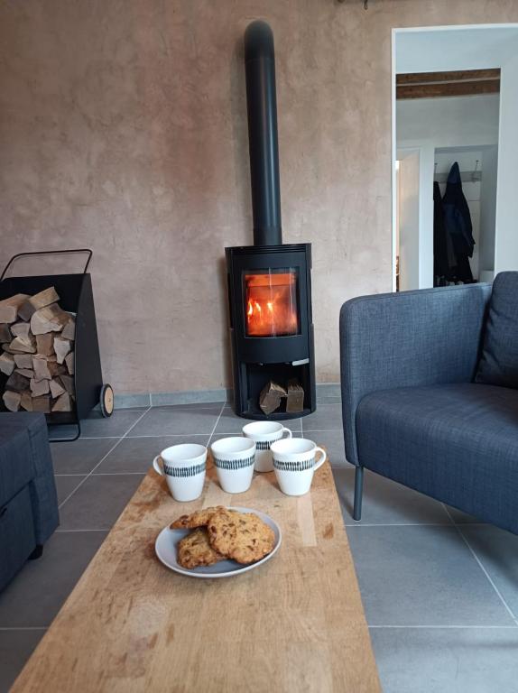 - une table avec une assiette de biscuits et une cheminée dans l'établissement La chartreuse authentique, à Entremont-le-Vieux