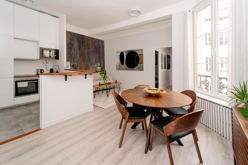 une cuisine et une salle à manger avec une table et des chaises en bois dans l'établissement Opéra-Galeries, à Paris