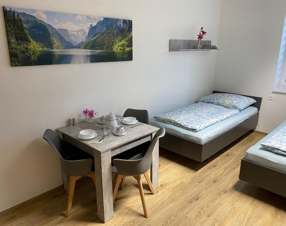 a room with a table and a bed and a table and chairs at JK Apartmány in Bělkovice