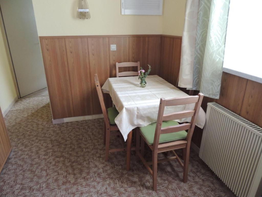 a dining room table with a white table and chairs at Ferienwohnung-Nr-2-Quitte in Radebeul