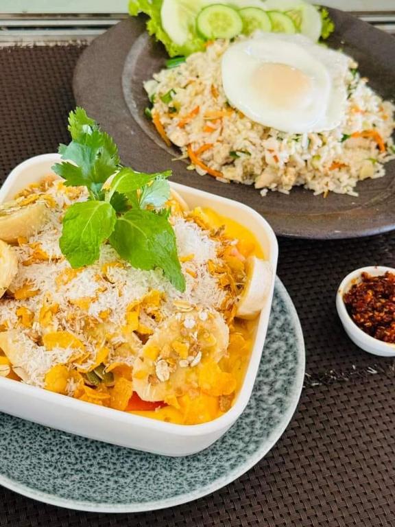 a plate of food with a bowl of food with rice at Frangipani Beach Villa in Tangalle
