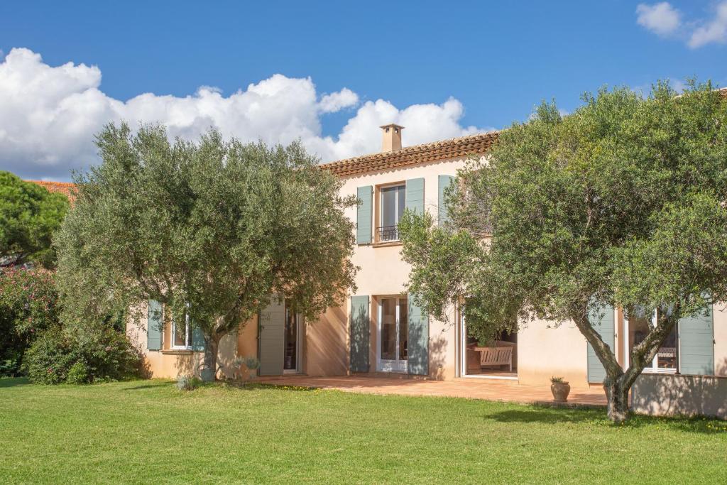 une grande maison avec des arbres devant elle dans l'établissement Villa familiale la Croix-du-Sud, à La Croix-Valmer