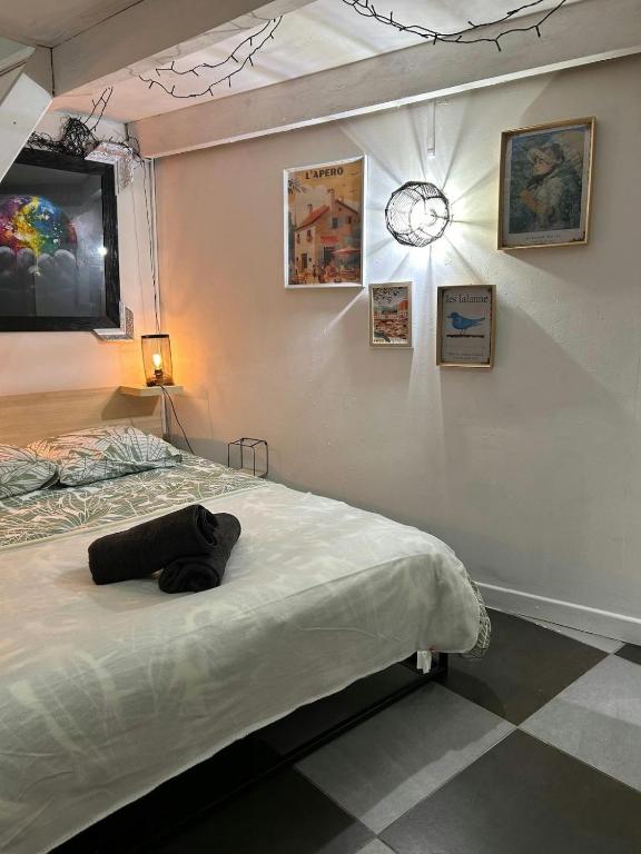 Cette chambre comprend deux lits et une horloge murale. dans l'établissement Le Marengo - clim - Gare- centre-ville, à Toulouse