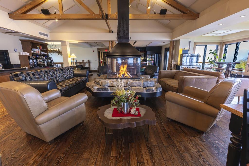 una hall con divani e un caminetto al centro di Auberge de Montagne des Chic-Chocs Mountain Lodge - Sepaq a Sainte-Anne-des-Monts