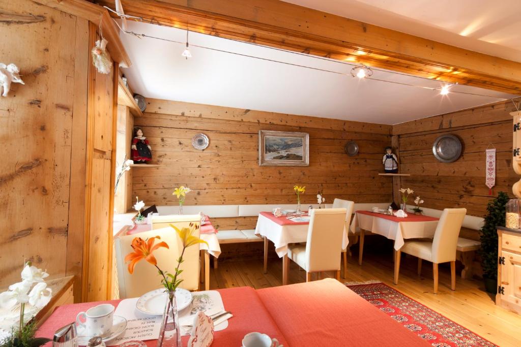 ein Restaurant mit Holzwänden, Tischen und Stühlen in der Unterkunft Hotel Chasa Sofia in Scuol