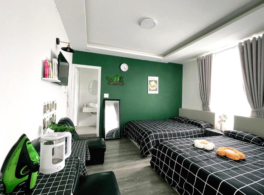 a room with two beds and green walls at DORA Boutique Hotel Dalat in Da Lat