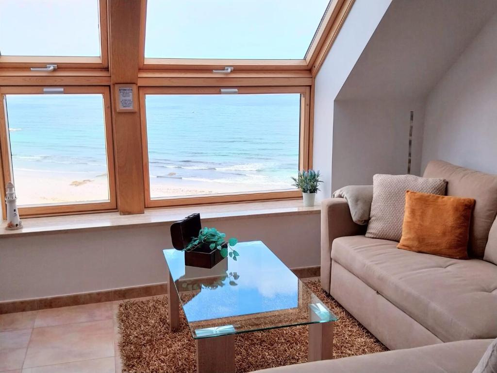 a living room with a couch and a view of the ocean at VISTA MAR apartamento con encanto in Malpica