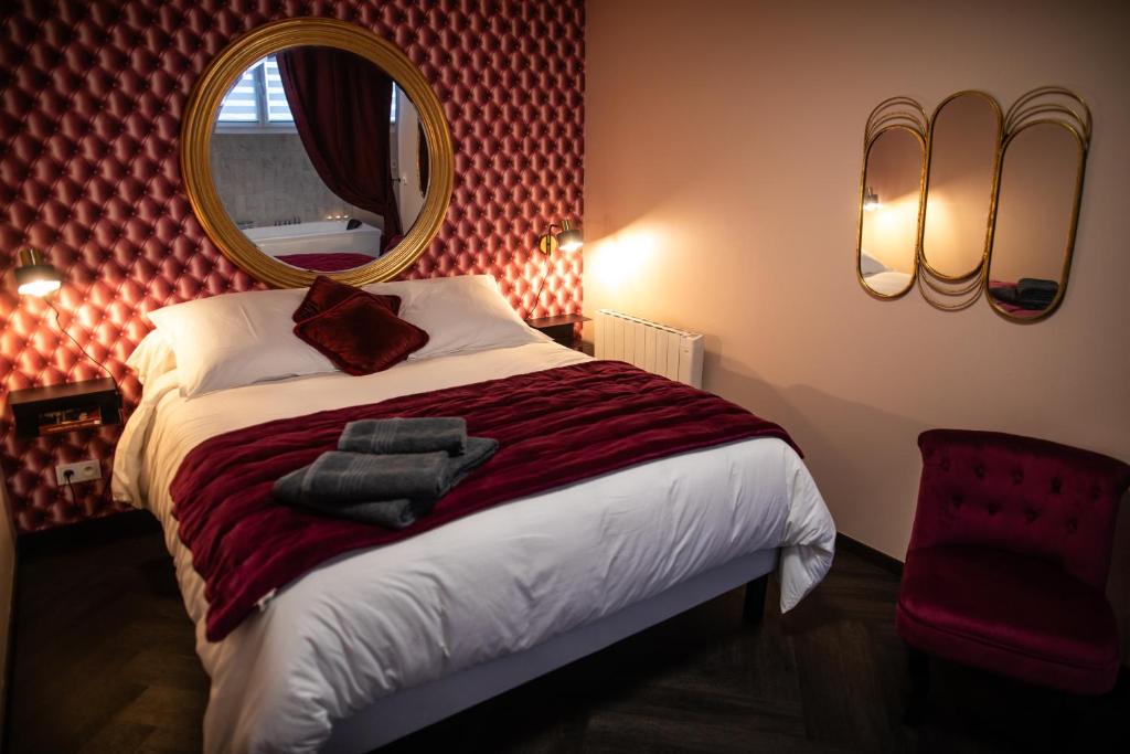 une chambre avec un lit avec un miroir au mur dans l'établissement Reflet des sens Love & Balnéo, à Sainte-Adresse