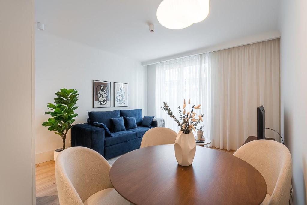 un soggiorno con un tavolo e un divano blu di GuestReady - A peaceful home near downtown a Porto