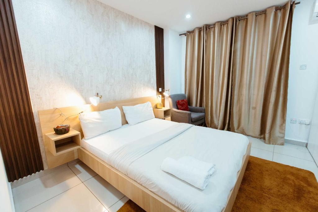 a bedroom with a large white bed and a window at Modern Studio Suite at The Gallery in Accra