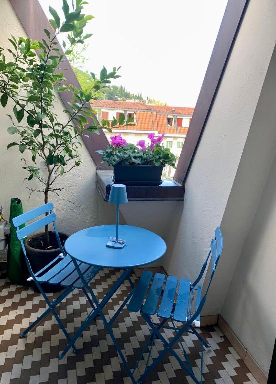a table and two chairs on a balcony with a window at SUN Holiday in Salò