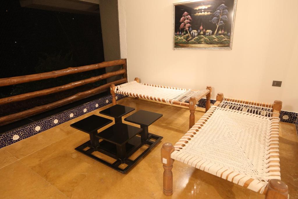 a room with two benches and a table at Golden Fields Resort in Mulshi