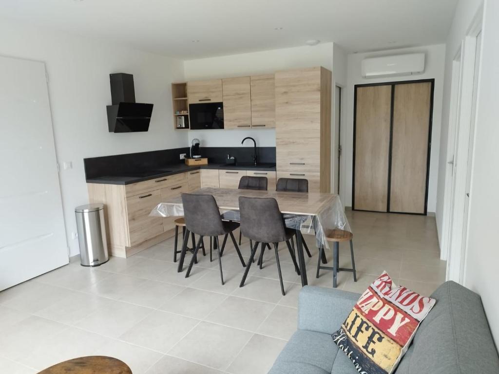 a kitchen and dining room with a table and chairs at La Villa d Isa in La Motte