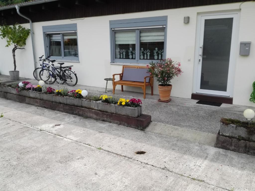 a house with a bench and flowers in front of it at Ferienwohnung Unter der Limburg in Bad Dürkheim-Hausen in Bad Dürkheim