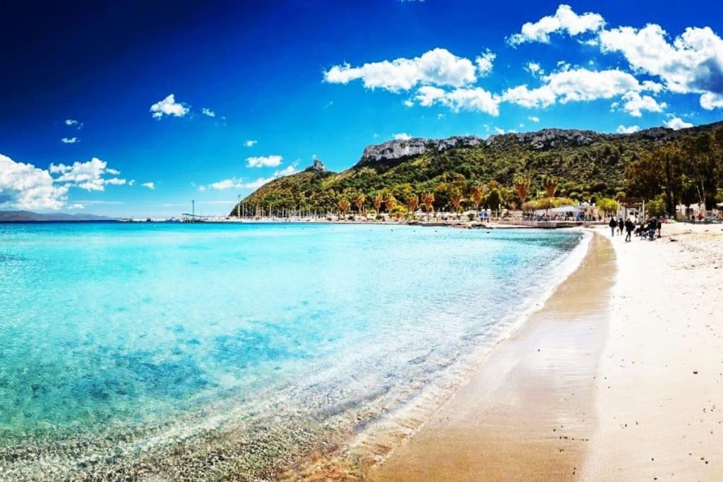 a beach with people walking on the sand and the water at -Giardino- Vakantiehuis tussen de olijvenbomen in Donori
