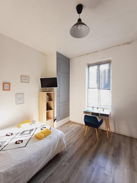 une chambre blanche avec un lit et un bureau dans l'établissement studio proche gare, à Agen