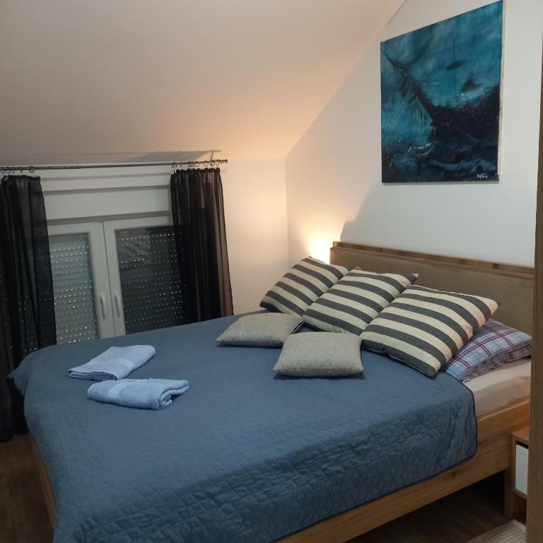 un letto con tre cuscini sopra di Apartman Prodan a Sombor