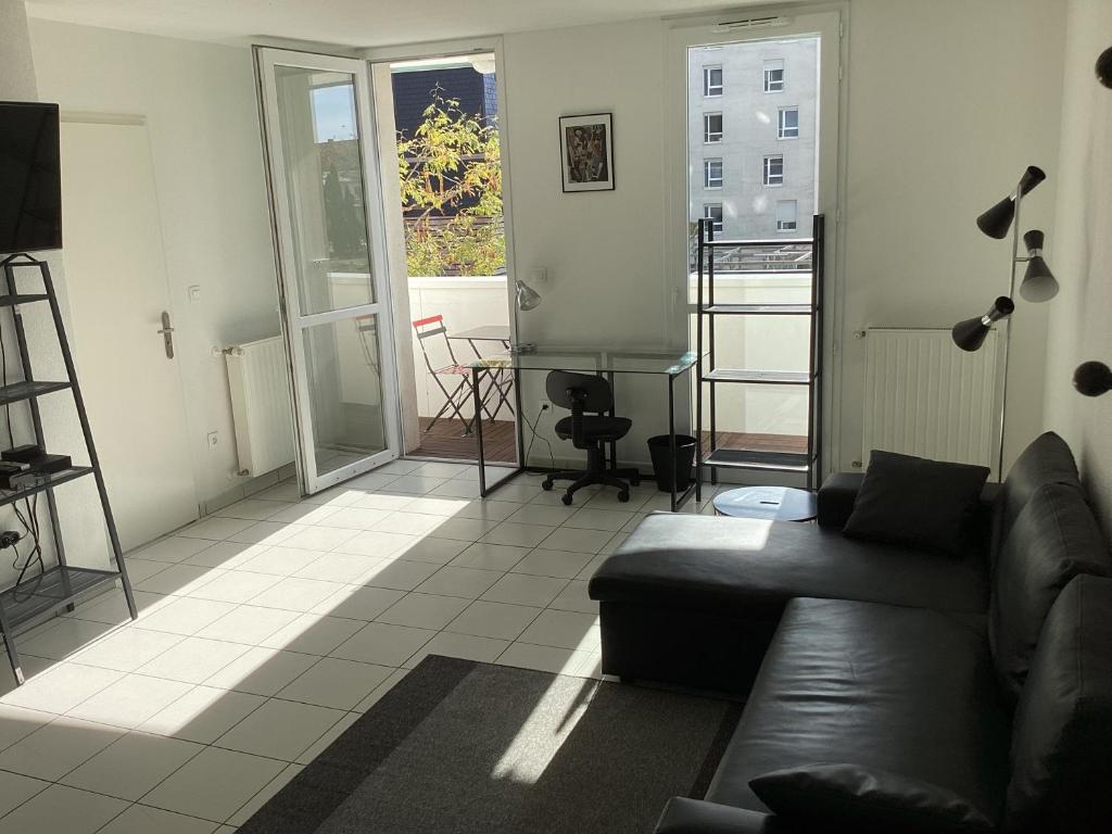 un salon avec un canapé et une grande fenêtre dans l'établissement T2 St Nazaire Ouest, à Saint-Nazaire