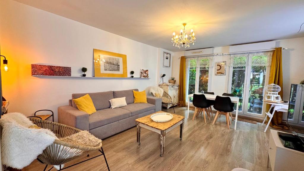un salon avec un canapé et une table dans l'établissement Magnifique Appartement 9min Disney, à Bailly-Romainvilliers