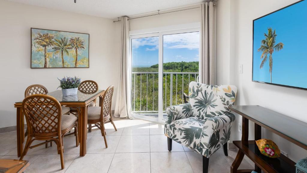ein Wohnzimmer mit Tisch und Stühlen und einem Fenster in der Unterkunft Modern and Coastal Ocean Pointe 2307 in Key Largo