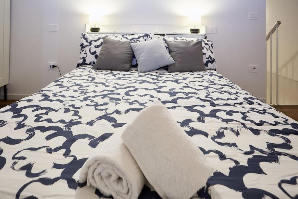 a bed with a blue and white blanket and pillows at Loft dal design raffinato a Vigonovo in Fontanafredda