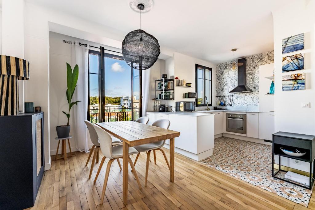 une cuisine et une salle à manger avec une table et des chaises en bois dans l'établissement Charmant Appartement Boulogne - 1 chambre, à Boulogne-Billancourt