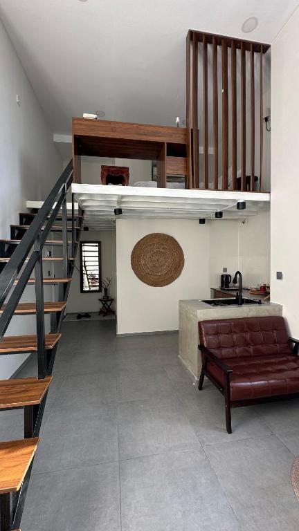 a living room with a staircase and a couch at Kors Loft Apartment in Phnom Penh