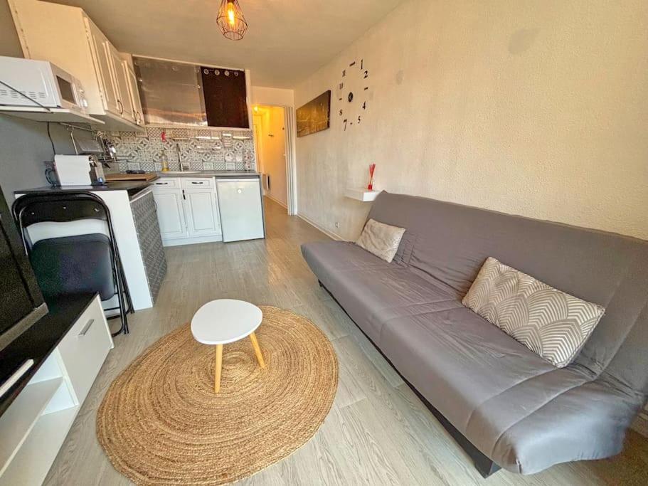 un salon avec un canapé gris et une table dans l'établissement Appartement 2P Terrasse - Clim, à Nice