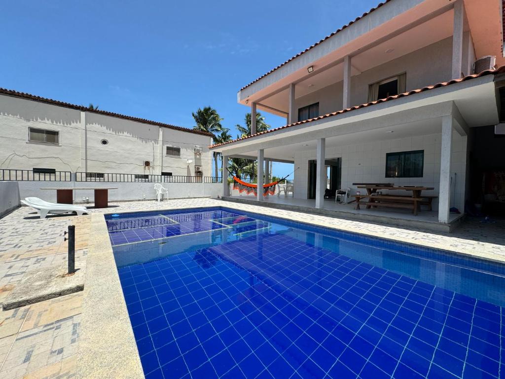 ein Swimmingpool vor einem Haus in der Unterkunft Casa Vista Mar Maragogi- Pé na areia in Peroba