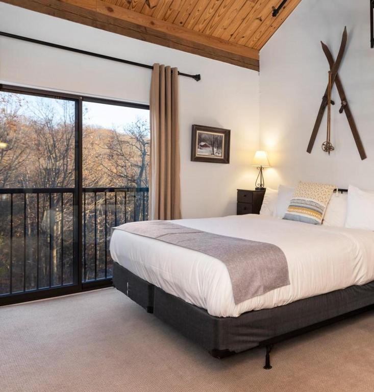 a bedroom with a large bed and a balcony at Mountain Inn Studio 53 with Wintergreen Advantage in Wintergreen