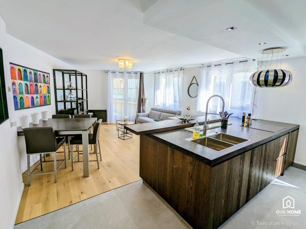 - une cuisine et un salon avec un comptoir et une table dans l'établissement Les Magnolias - Calme - Confort - Parking - Tram, à Orléans