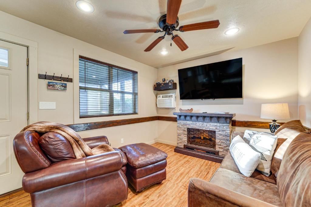 a living room with leather furniture and a flat screen tv at Pool + Walk to Lake! Little Indian Resort Cabin in Lampe
